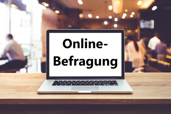 Ein Laptop mit dem Schriftzug Online-Befragung auf dem Bildschirm
