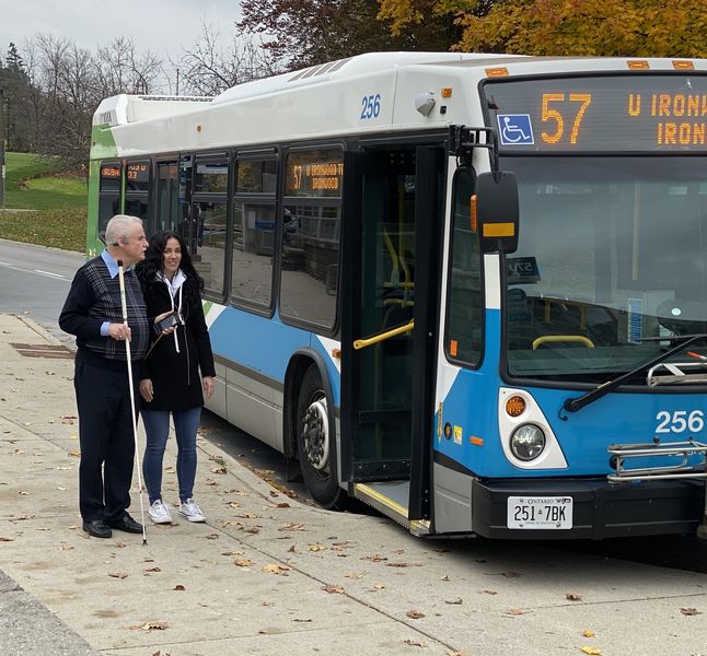 Eine blinder Mann nutzt mit Hilfe einer Begleitung BlindSquare