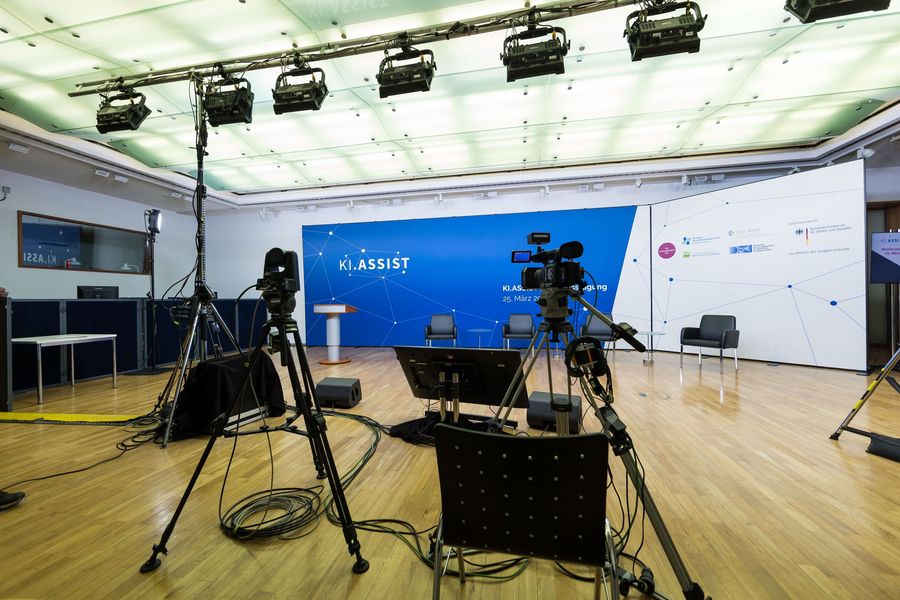 Räumlichkeiten der Abschlusstagung mit Kameras und Hintergrundbanner