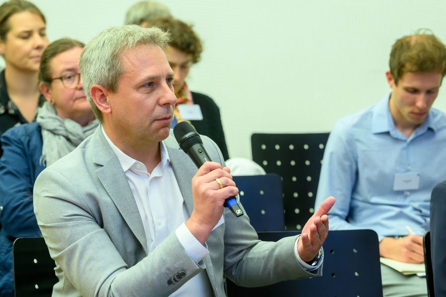 Ein Mann stellt eine Frage an eine Rednerin