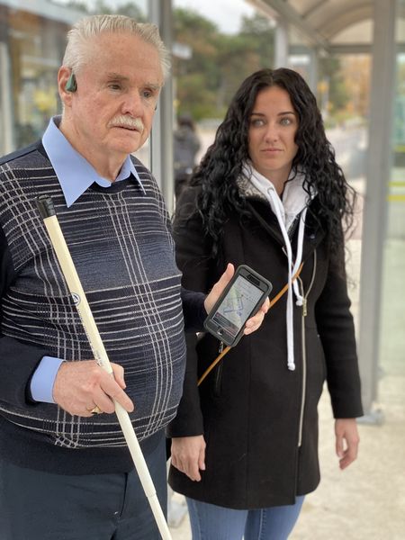 Eine blinder Mann nutzt mit Hilfe einer Begleitung BlindSquare