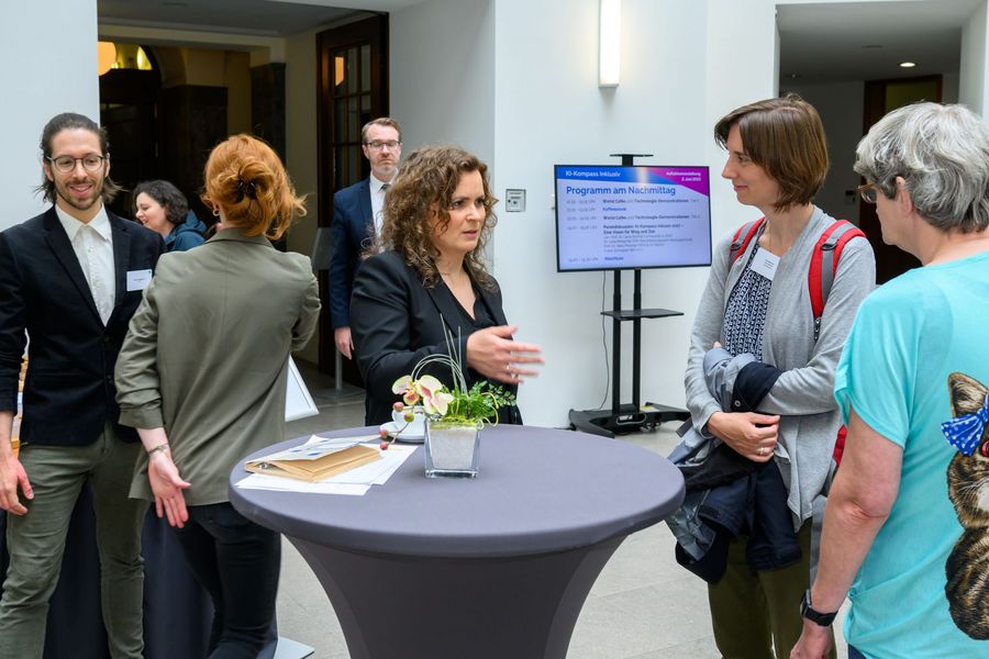 Teilnehmende unterhalten sich im Foyer