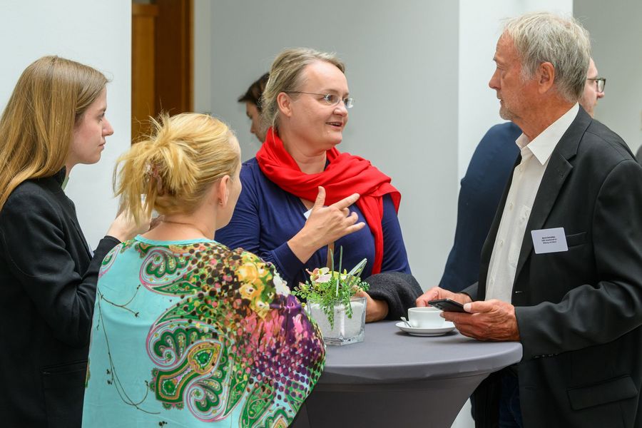 Teilnehmende unterhalten sich im Foyer
