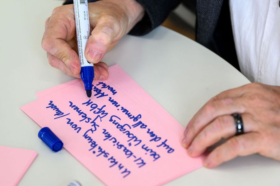 Teilnehmender füllt Kärtchen aus