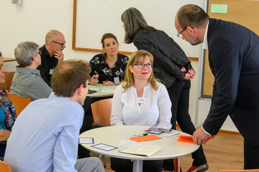 Teilnehmende arbeiten im World Cafe